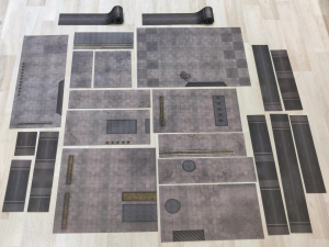 Cut-up parts of the cityscape battle mat laid out together on the floor
