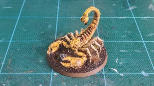 Painted Greater Mutant Scorpion miniature alongside for 28mm scale games — front-left view