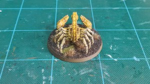Painted Greater Mutant Scorpion miniature alongside for 28mm scale games — rear view