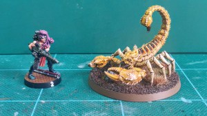 Painted Greater Mutant Scorpion miniature alongside a 28mm scale human miniature (2)